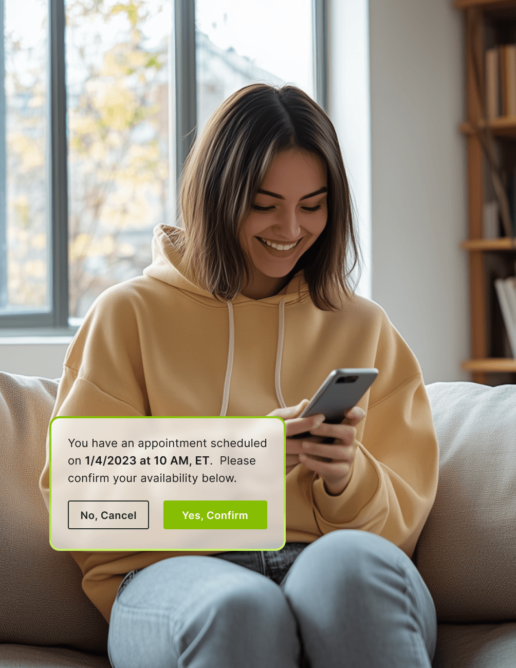 Woman in a yellow hoodie smiling at her phone, with a screen notification about confirming a scheduled appointment.