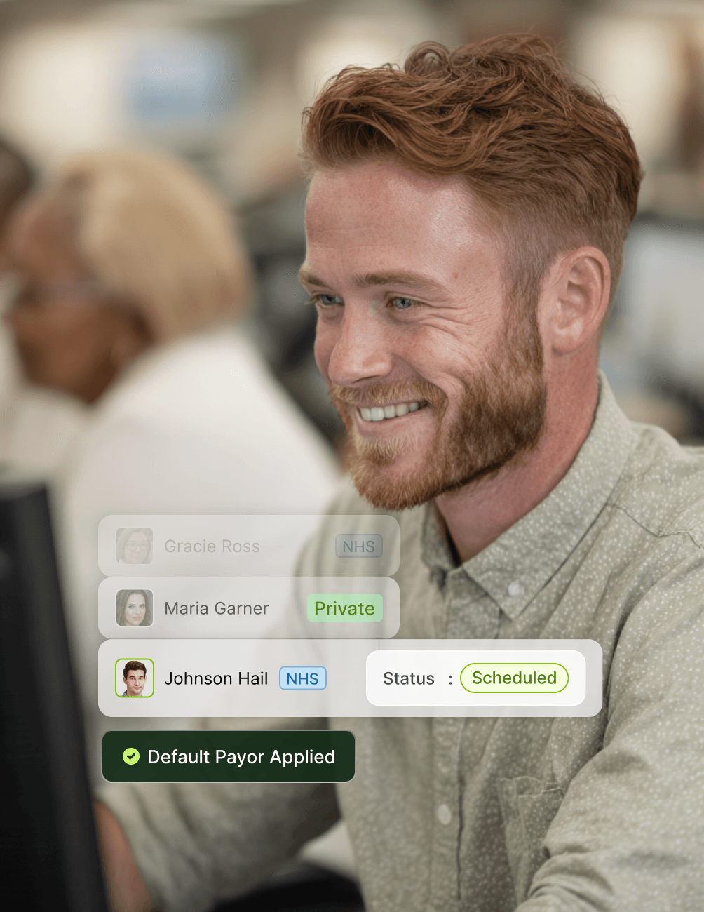 A smiling man with a beard looks at a screen showing patient information and scheduling status, with "Default Payor Applied" marked.