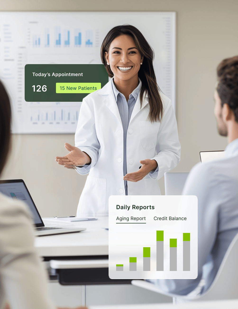 A dentist in a white coat smiles while presenting to colleagues. Nearby, a screen displays appointment stats and daily reports with graphs.